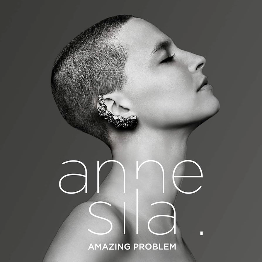 White and black (and grey) album cover of a picture of Anne Sila from the side, eyes closed, with trimmed hair and a big rocky shiny jewel around the shape of her ear. 
