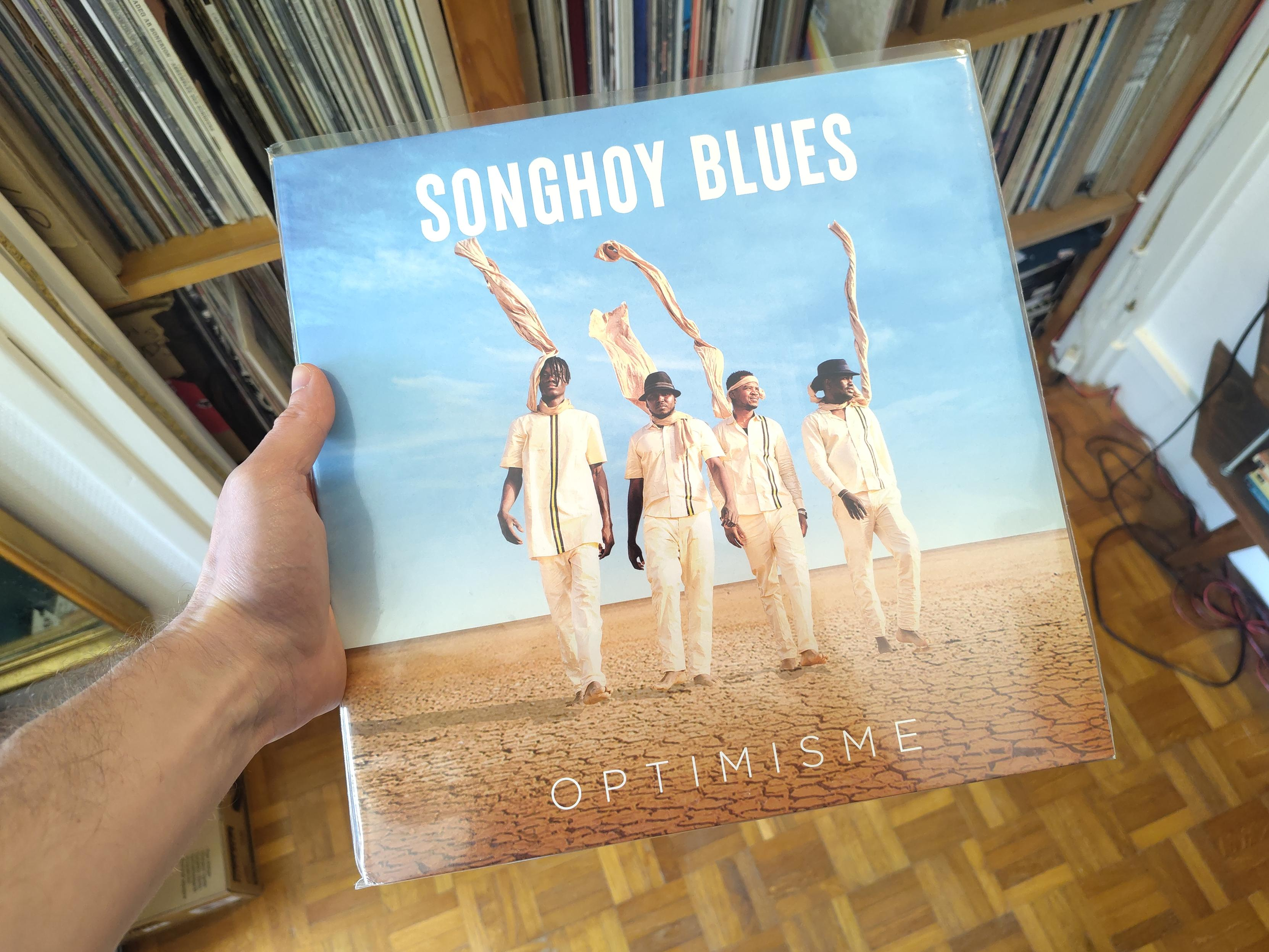 Les musiciens, quatre hommes noirs habillés de blanc, marchent vers nous en ligne, dans un désert. Ils portent des écharpes de la même couleur qui volent vers le haut. Un ciel très bleu occupe les deux-tiers supérieurs de la pochette.