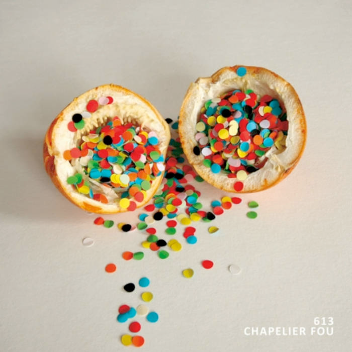 A picture of a maracuja sliced in two and opened with confettis inside and around like it's dripping on a white background.