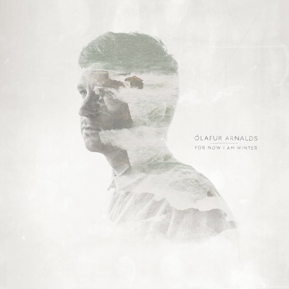 On a white background, a picture of Ólafur Arnalds almost desaturated where whe can see some rocks and the sea inside his head.