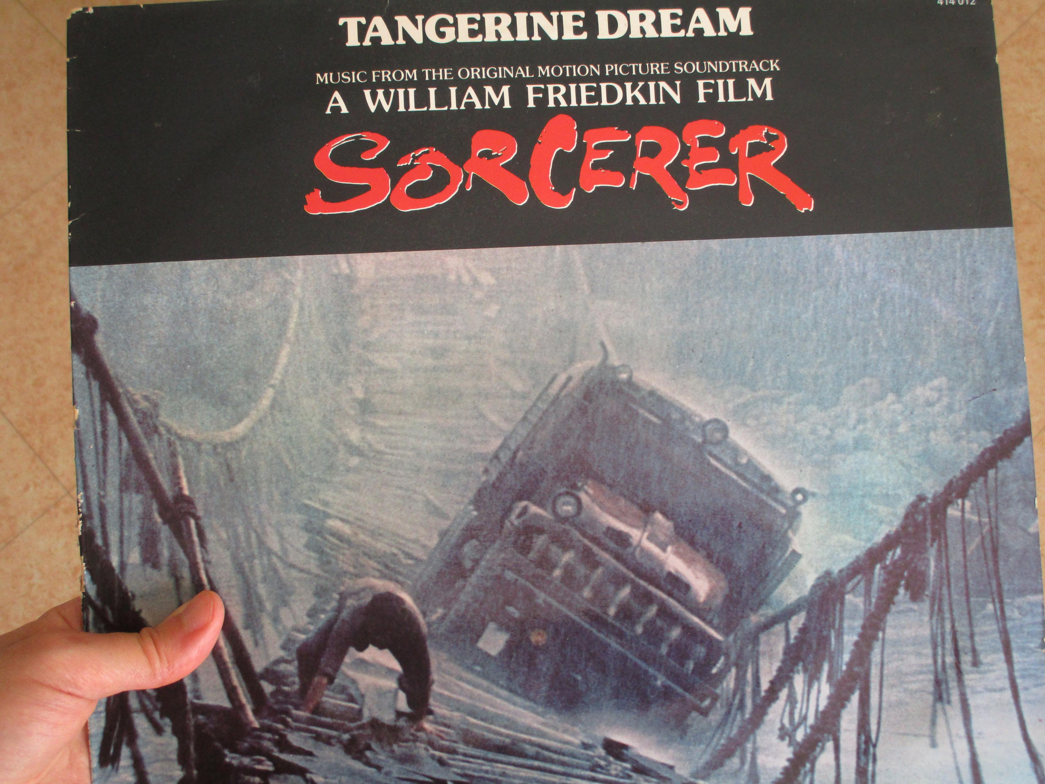 Ma main gauche tenant le 33T de la BO du film de Sorcerer de Friedkin par le groupe Tangerine Dream, illustré par la séquence incroyable du passage du camion le plus dangereux du monde sur une passerelle non adaptée, sous un déluge de pluie, au-dessus d'un torrent, un homme se cramponnant à quatre pattes sur les lattes